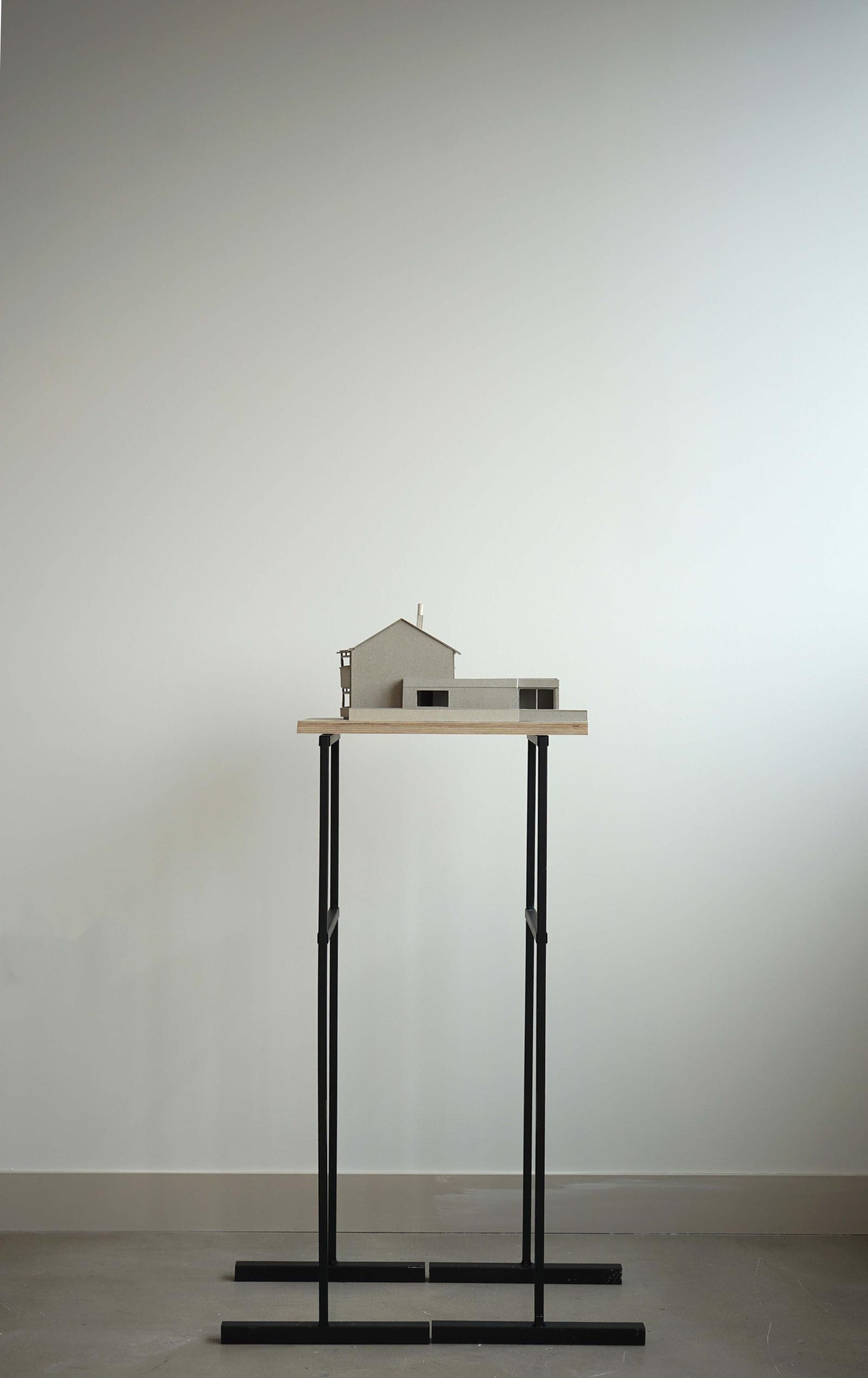 1:50 Building model of Carlton Road. 

Grey board existing and proposed building model with a plywood base, sited on two steel plinths.